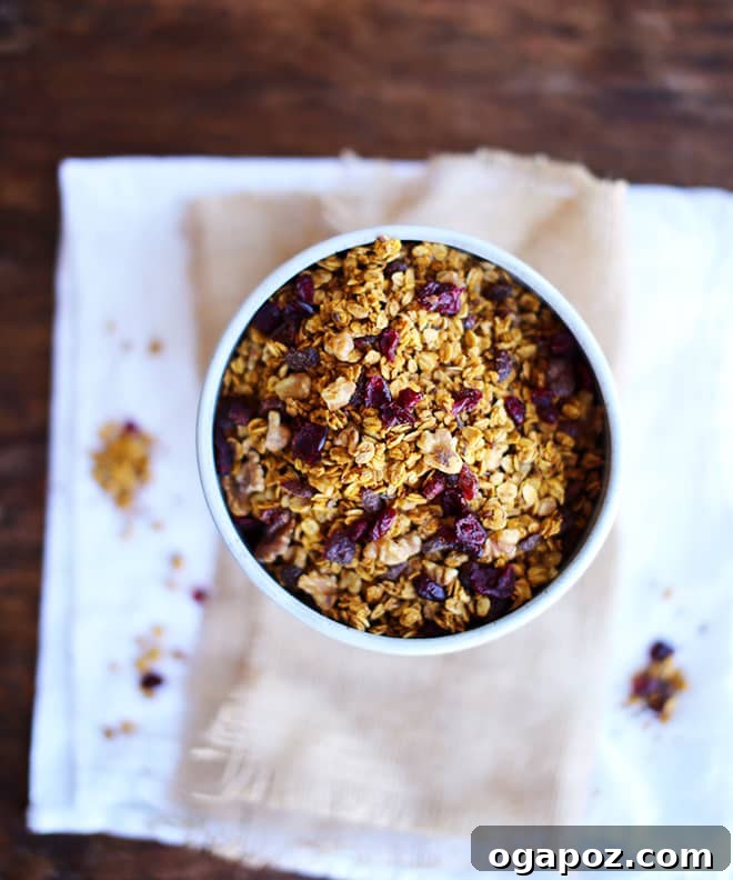 Spiced Autumn Pumpkin Granola 2 A glass jar filled with homemade pumpkin granola and a bowl of granola with milk.