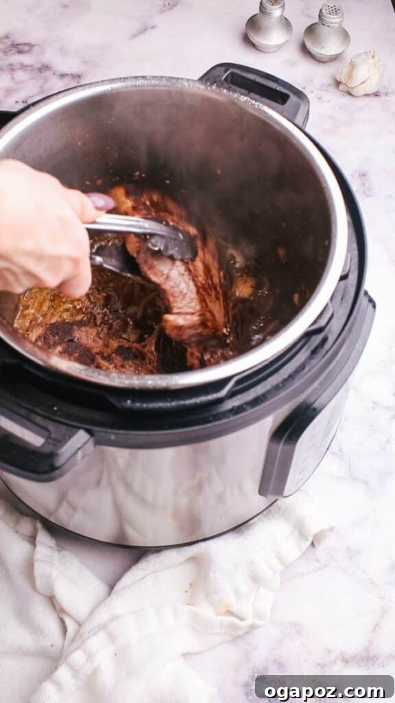 Instant Pot Steak: Fork-Tender Perfection with Savory Pan Sauce 10 Removing cooked steak from the Instant Pot.