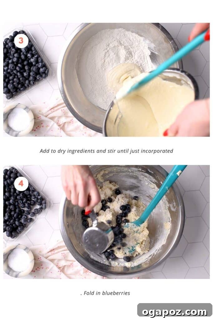 Blueberry Lemon Sour Cream Muffins 5 A baker gently adding wet ingredients to a bowl of dry mixture with a spatula, carefully stirring until just combined, followed by folding in fresh blueberries to create a lump-free muffin batter.