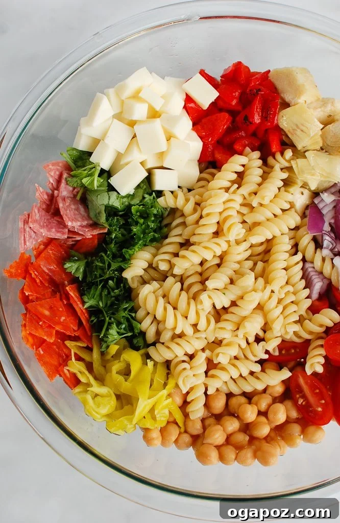 Savory Italian Pasta Medley 3 An overhead view of various fresh Italian Pasta Salad ingredients laid out on a wooden board.
