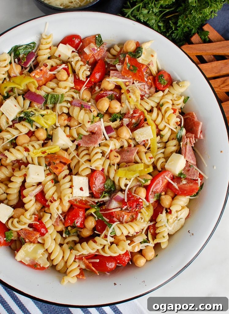 Savory Italian Pasta Medley 5 A bowl of Italian Pasta Salad being served with wooden salad spoons.