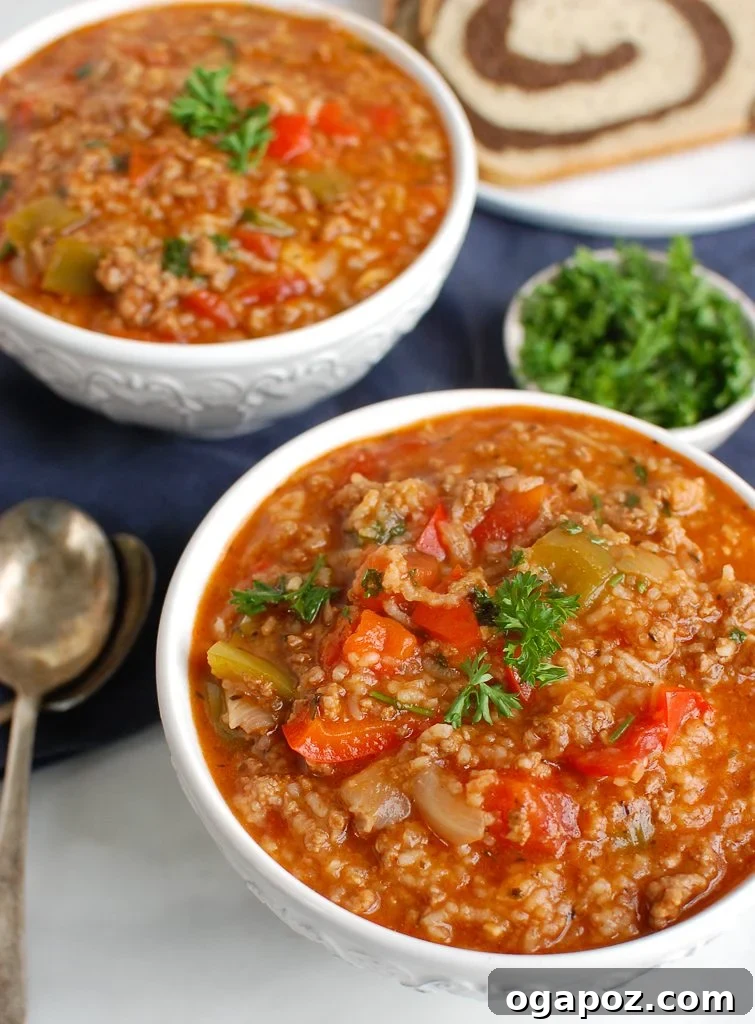 Hearty Instant Pot Stuffed Pepper Soup 3 Two white bowls filled with Instant Pot Stuffed Pepper Soup, garnished with fresh parsley.