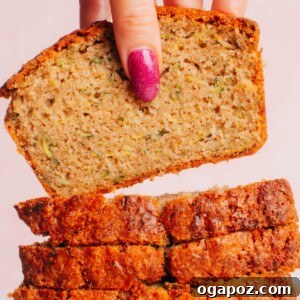 A pile of sliced zucchini bread with the top slice lifted up.
