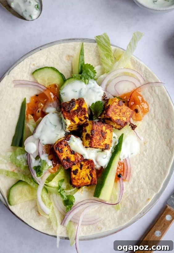 Paneer Perfection: 52+ Recipes for Every Palate 11 Delicious Spiced Paneer Wrap, filled with paneer, vegetables, and creamy yogurt, served on a plate.