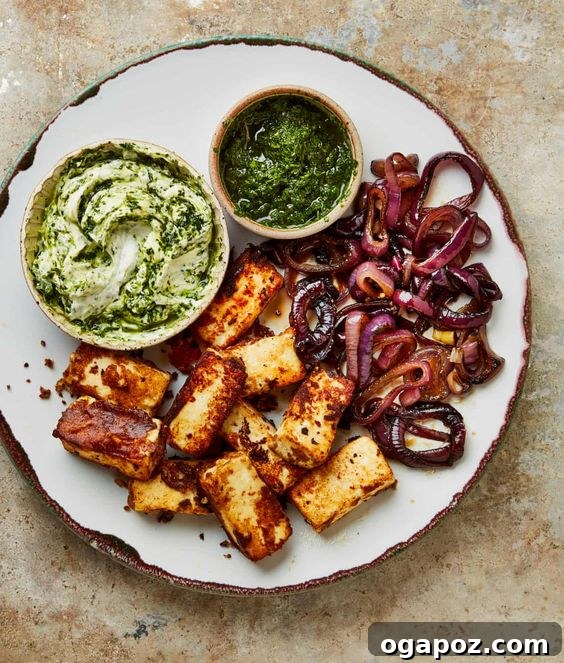 Paneer Perfection: 52+ Recipes for Every Palate 13 Flavorful Koftas in Spicy Sauce, served with charred onions and fresh green salsa, a vibrant dish.