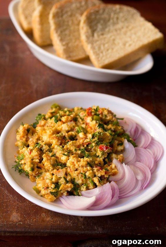 Paneer Perfection: 52+ Recipes for Every Palate 19 Hearty Paneer Bhurji, a spiced scrambled cottage cheese dish, served on a plate with fresh onion slices.