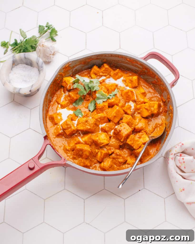 Paneer Perfection: 52+ Recipes for Every Palate 4 Luxurious Butter Paneer curry, a classic Indian dish, simmering gently in a pan with a serving spoon, inviting pure comfort.
