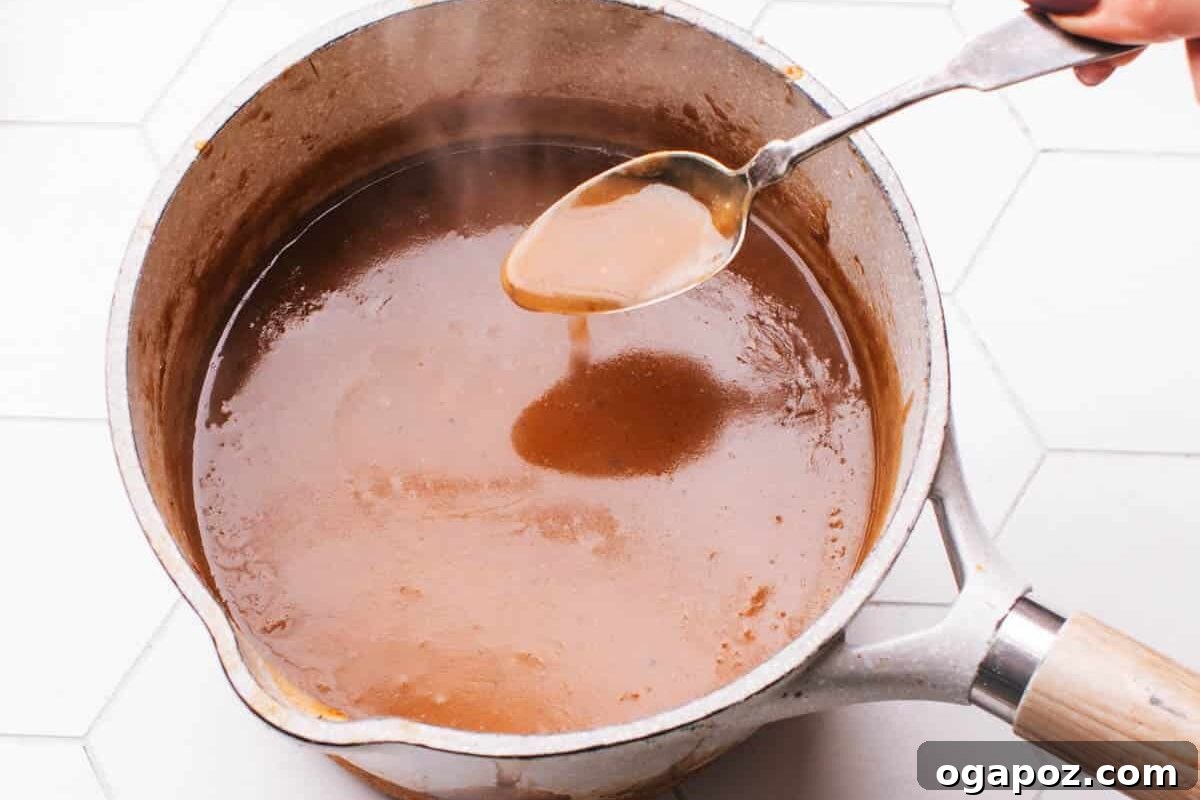 Ultra Juicy Air Fryer Roast Beef 7 Brown Gravy in a pot with a spoon.