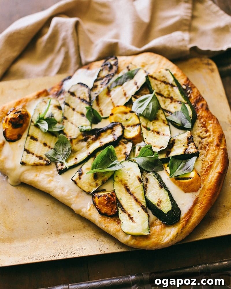 Summer Grilled Zucchini Flatbread 3 Another angle of the gourmet grilled pizza, showcasing its perfectly melted cheese and fresh basil, ready to be enjoyed.