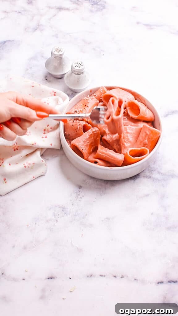 Creamy Beetroot Pasta Delight 12 Taking a spoonful of pasta with beet pasta sauce, showing its creamy texture.