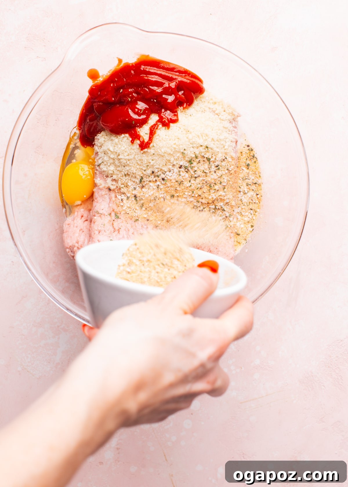 Ultimate Meatloaf Flavor Mix 4 Adding a generous amount of homemade seasoning mix to ground turkey in a large mixing bowl.