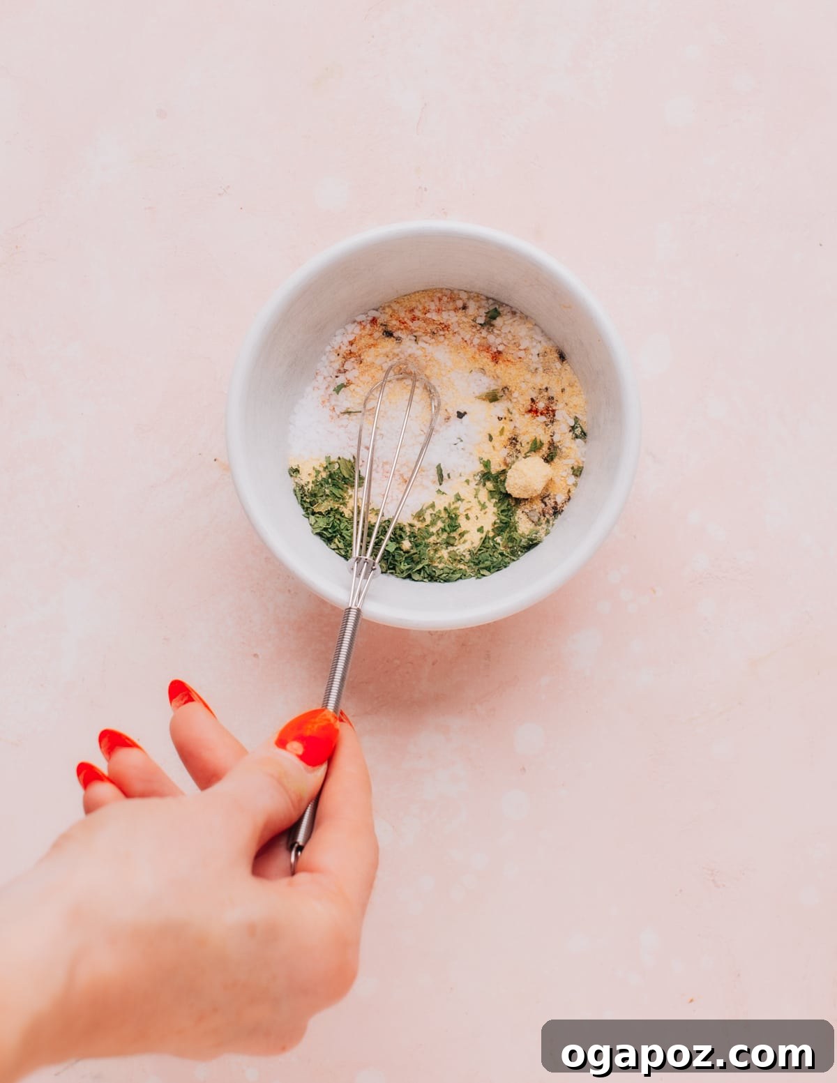 Ultimate Meatloaf Flavor Mix 6 A person's hands gently mixing the homemade meatloaf seasoning blend in a clear bowl.