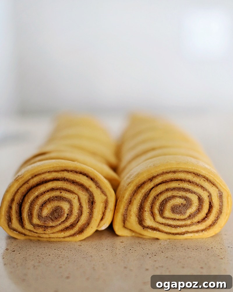 Pumpkin Spice Cinnamon Rolls with Cream Cheese Frosting 4 Unbaked pumpkin cinnamon rolls arranged in a baking pan, ready for their second rise.