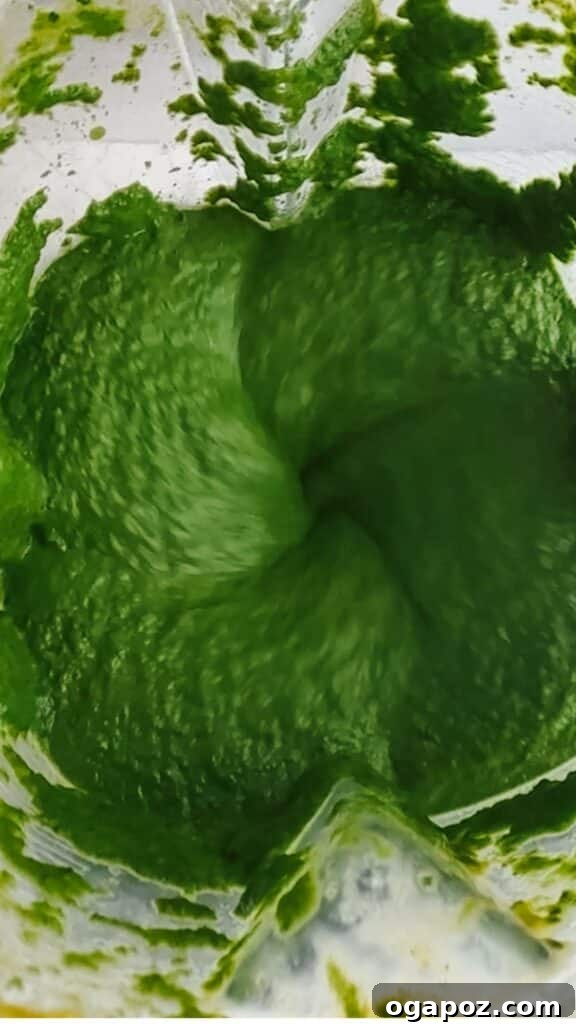 Velvety Palak Paneer 8 Spinach and spice mixture being blended to a smooth puree in a blender.