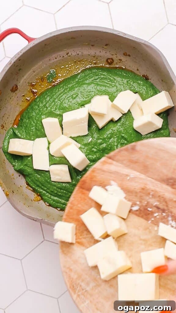 Velvety Palak Paneer 9 Soft paneer cubes being added to the simmering green spinach gravy.