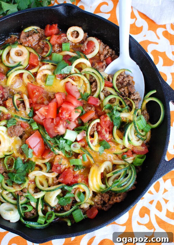 Zesty Mexican Zucchini Medley 5 Overhead view of Mexican Zucchini in a black skillet, garnished with fresh cilantro and green onions.