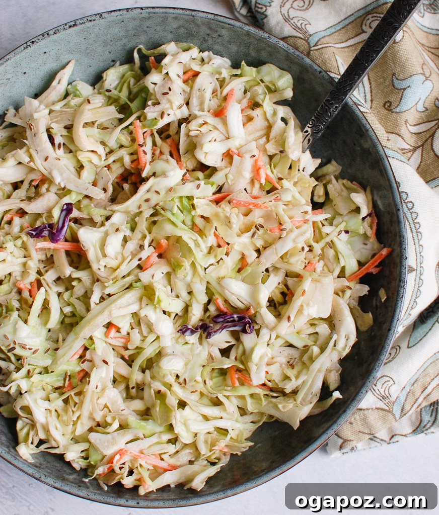 Ultimate Creamy Coleslaw 6 A large bowl of creamy coleslaw with a serving spoon, ready to be dished out.