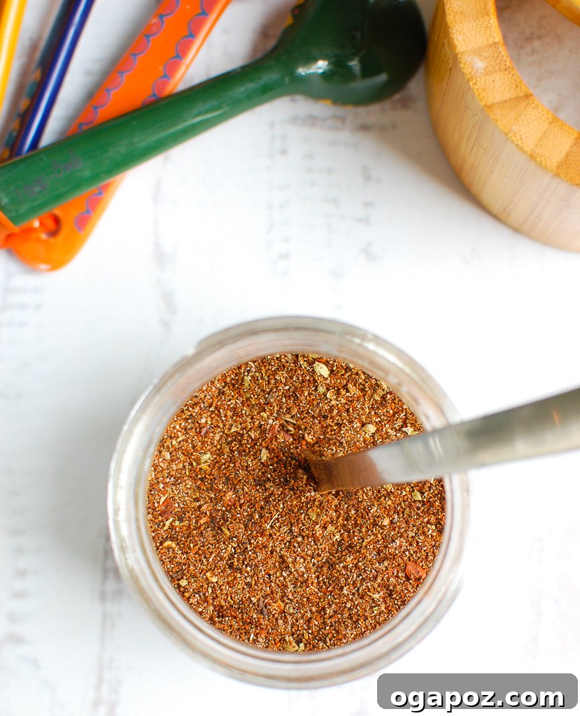 Better-Than-Store-Bought Taco Seasoning 5 Homemade Taco Seasoning Recipe with a spoon scooping the blend from a jar