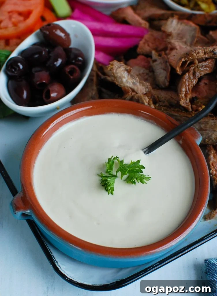Creamy Tahini Dressing 2 Creamy Homemade Tahini Sauce in a teal bowl, garnished with parsley, ready to be served with Mediterranean dishes