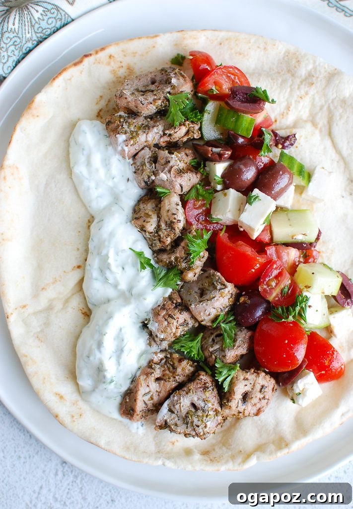 Mediterranean Grilled Pork Skewers with Cooling Tzatziki 2 Grilled Pork Souvlaki with Tzatziki and pita on a plate, garnished with fresh herbs