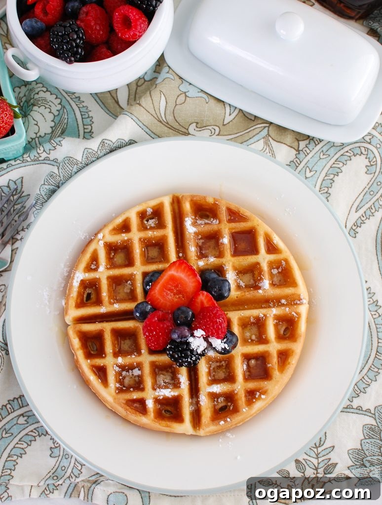 Elevated Greek Yogurt Waffles 4 A stack of Greek Yogurt Waffles topped with fresh berries and powdered sugar