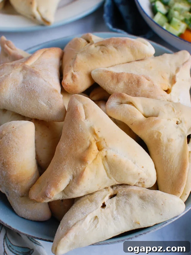 Sfiha: Traditional Lebanese Meat Pies 2 A blue bowl filled with golden-brown Lebanese Meat Pies, ready to be served.