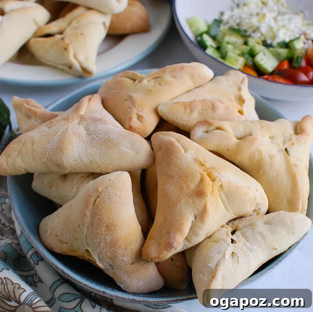 Sfiha: Traditional Lebanese Meat Pies 4 A vibrant spread of Lebanese Meat Pies, fresh salads, and cooling cucumber slices on a wooden board.