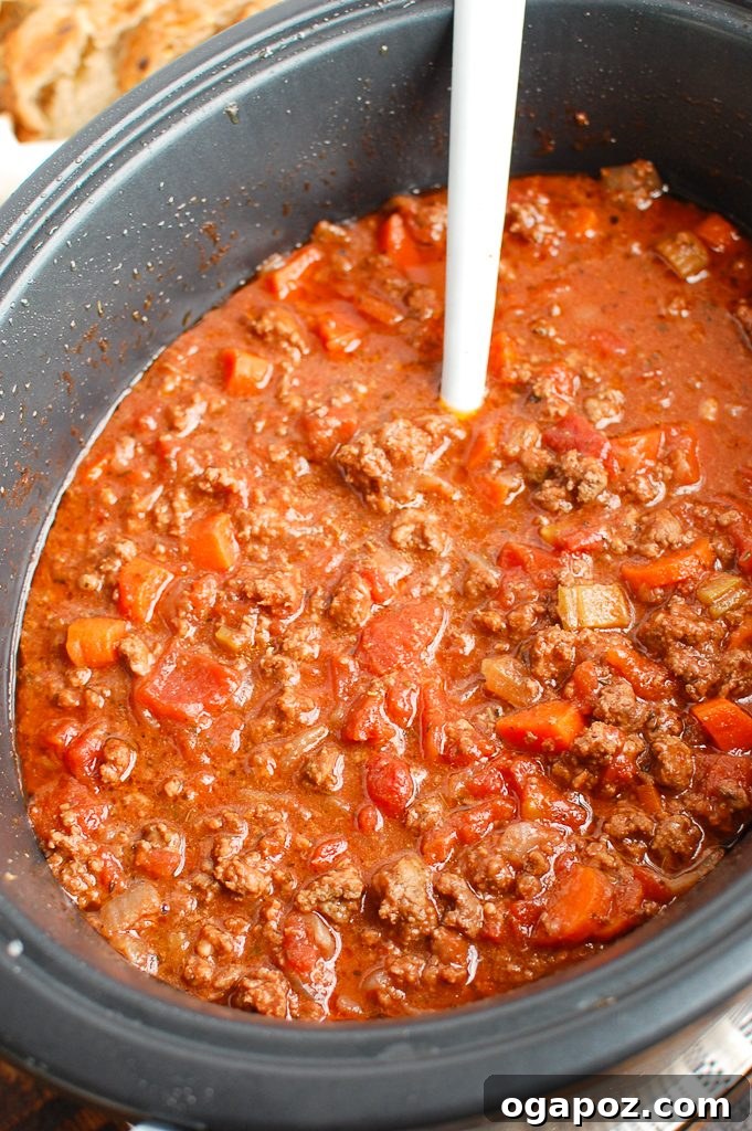 Slow Cooker Spaghetti Sauce with a white spoon