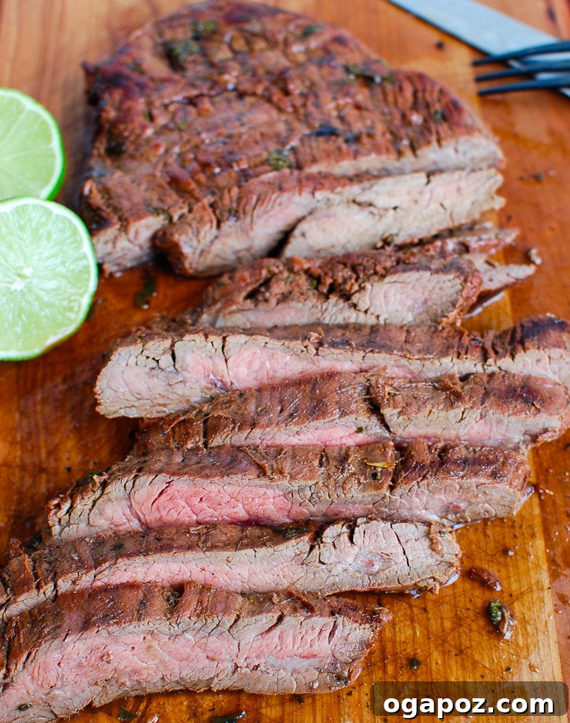 Perfectly Grilled Carne Asada on a cutting board, ready to be sliced, with a knife nearby