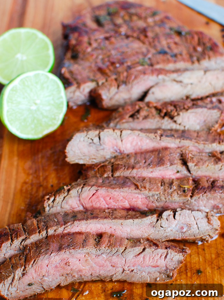 Sliced Grilled Carne Asada with a fork, showcasing its tenderness