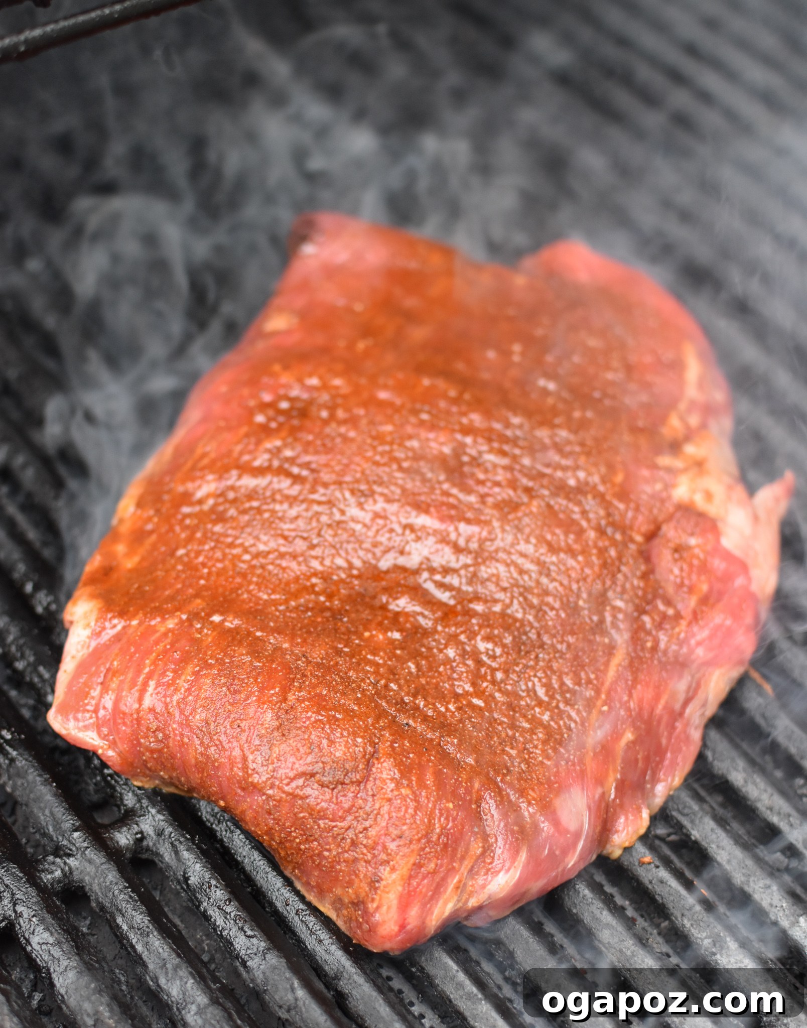 Flank Steak with dry rub on the grill, sizzling and cooking to perfection