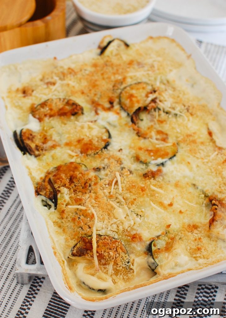 Golden Zucchini Bake 5 A serving of Zucchini Gratin in a white dish, showing its layered texture and appealing colors.