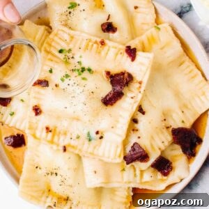 Pouring browned butter over fresh homemade ravioli, highlighting a delectable serving suggestion.