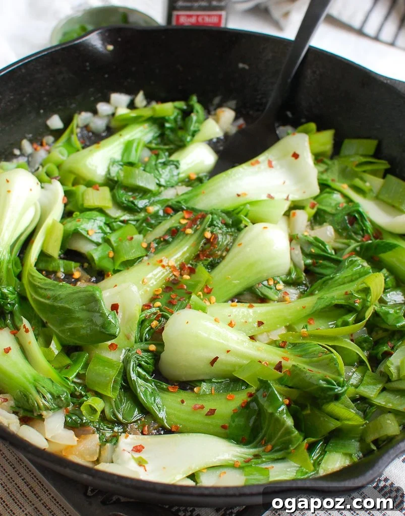 No-Fuss Garlic Bok Choy 3 Fresh bok choy and other ingredients laid out in a cast iron skillet, ready for cooking