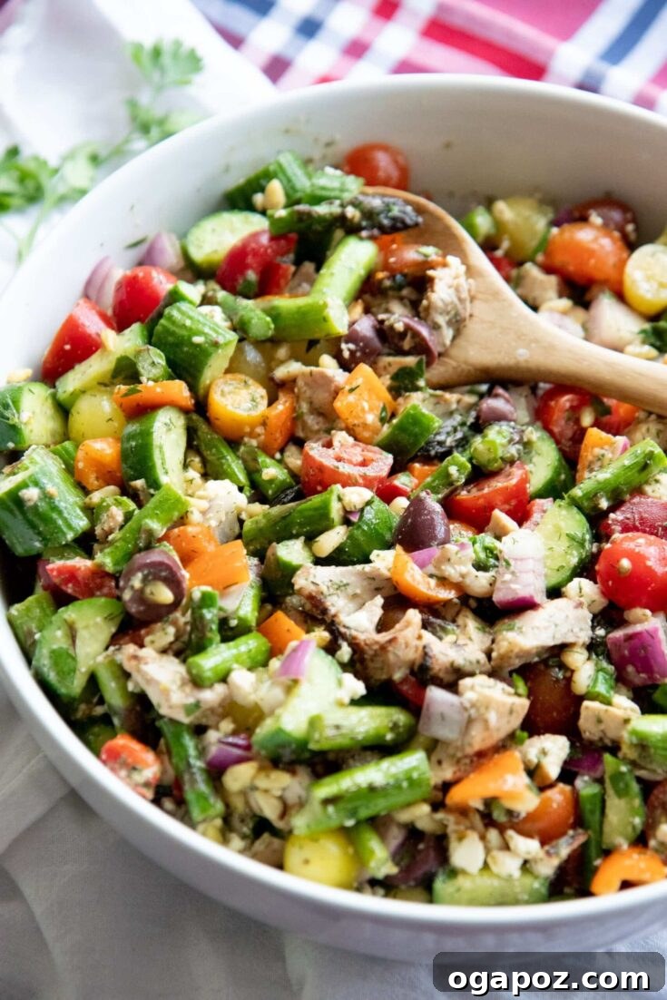 A beautifully presented Grilled Chicken and Asparagus Chopped Greek Salad, featuring succulent chicken, crisp asparagus, feta, olives, and fresh greens.