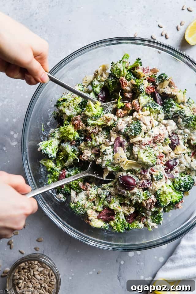 A Mediterranean Low Carb Broccoli Salad, showcasing raw broccoli florets mixed with colorful bell peppers, olives, and a light dressing.