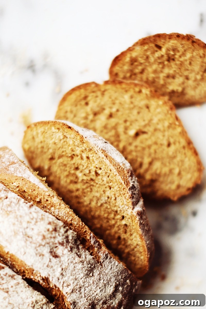 Two freshly baked loaves of oatmeal brown bread, hot out of the oven, exhibiting a rich golden brown crust.