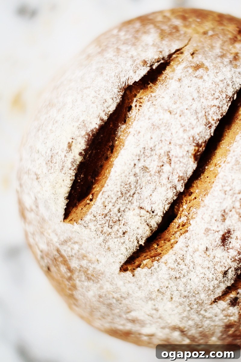 A close-up view of a perfectly sliced loaf of cool oatmeal brown bread, revealing its moist, even crumb.
