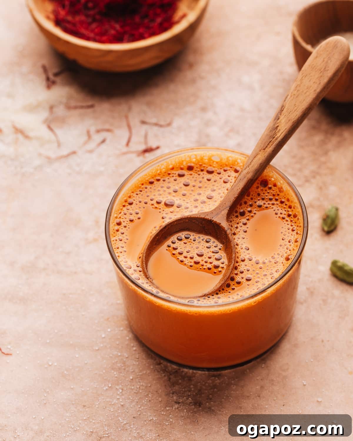 Authentic Karak Chai Made Simple 3 A glass of Karak Chai with a spoon, showing its thick, creamy texture and rich color, ready to be enjoyed.