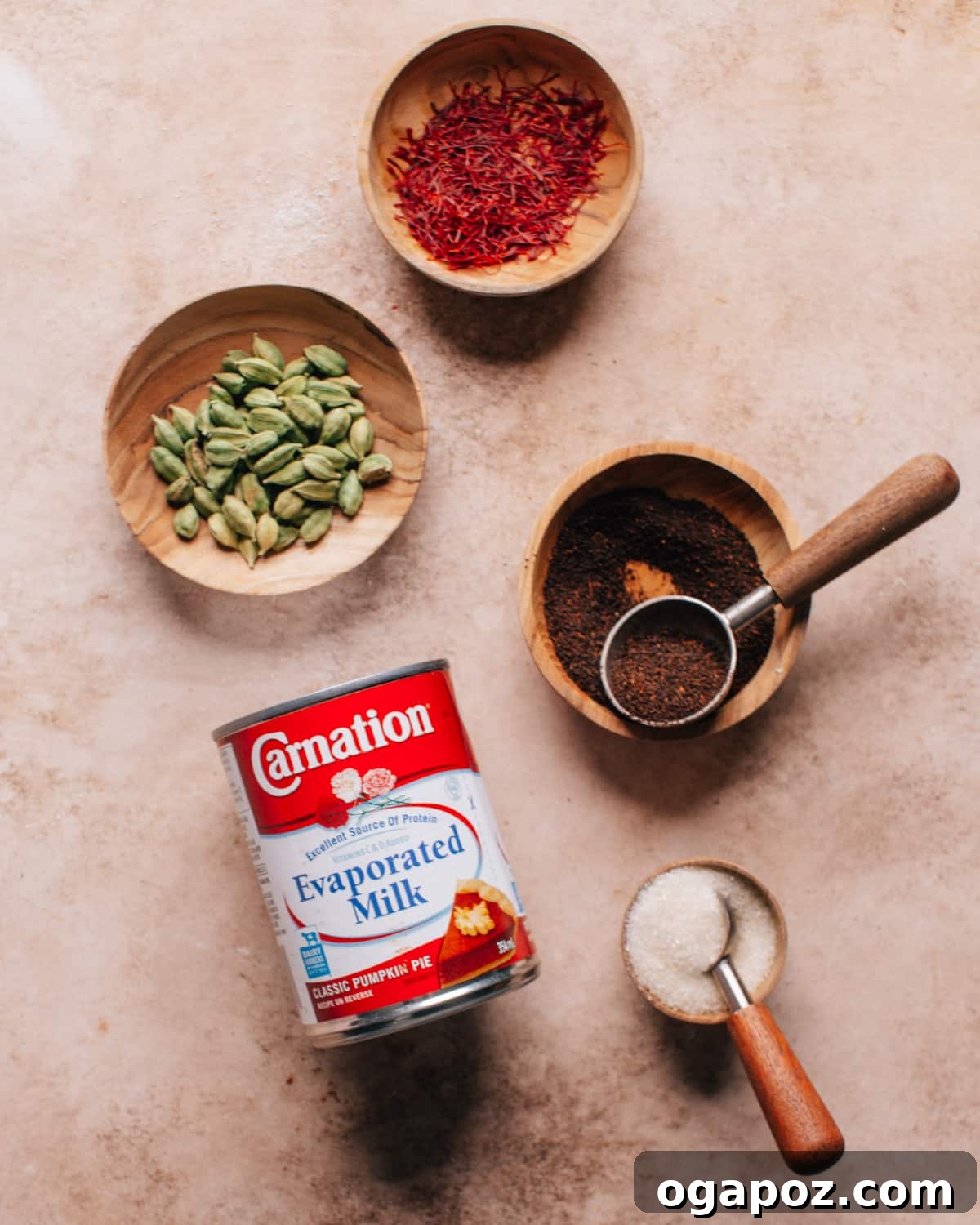 Authentic Karak Chai Made Simple 5 All the ingredients laid out for making Karak Chai: black tea, cardamom pods, saffron, evaporated milk, and sugar.
