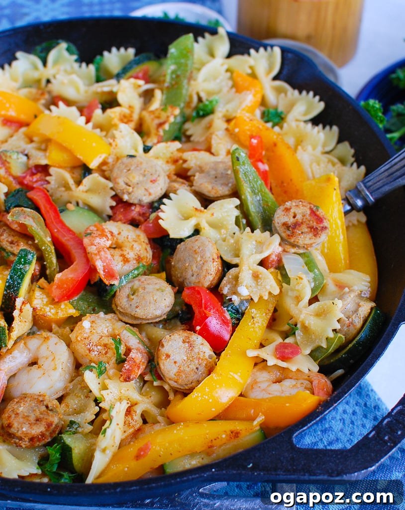 Fiery Cajun Pasta with Chicken Sausage and Shrimp 5 A spoon scooping creamy Cajun Pasta with Chicken Sausage and Shrimp from a bowl, highlighting the rich texture.