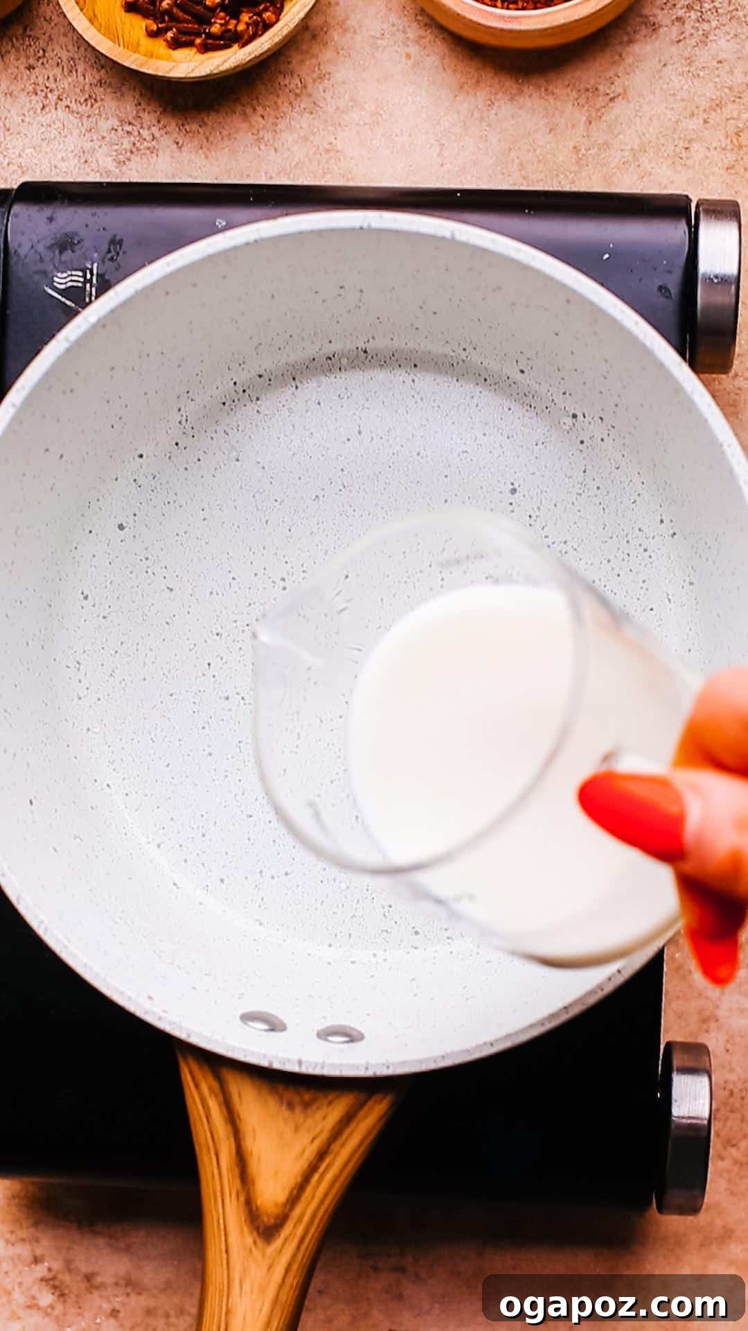 Velvet Froth Chai Coffee Delight 5 Adding milk to a saucepan with chai spices, ready for infusion.