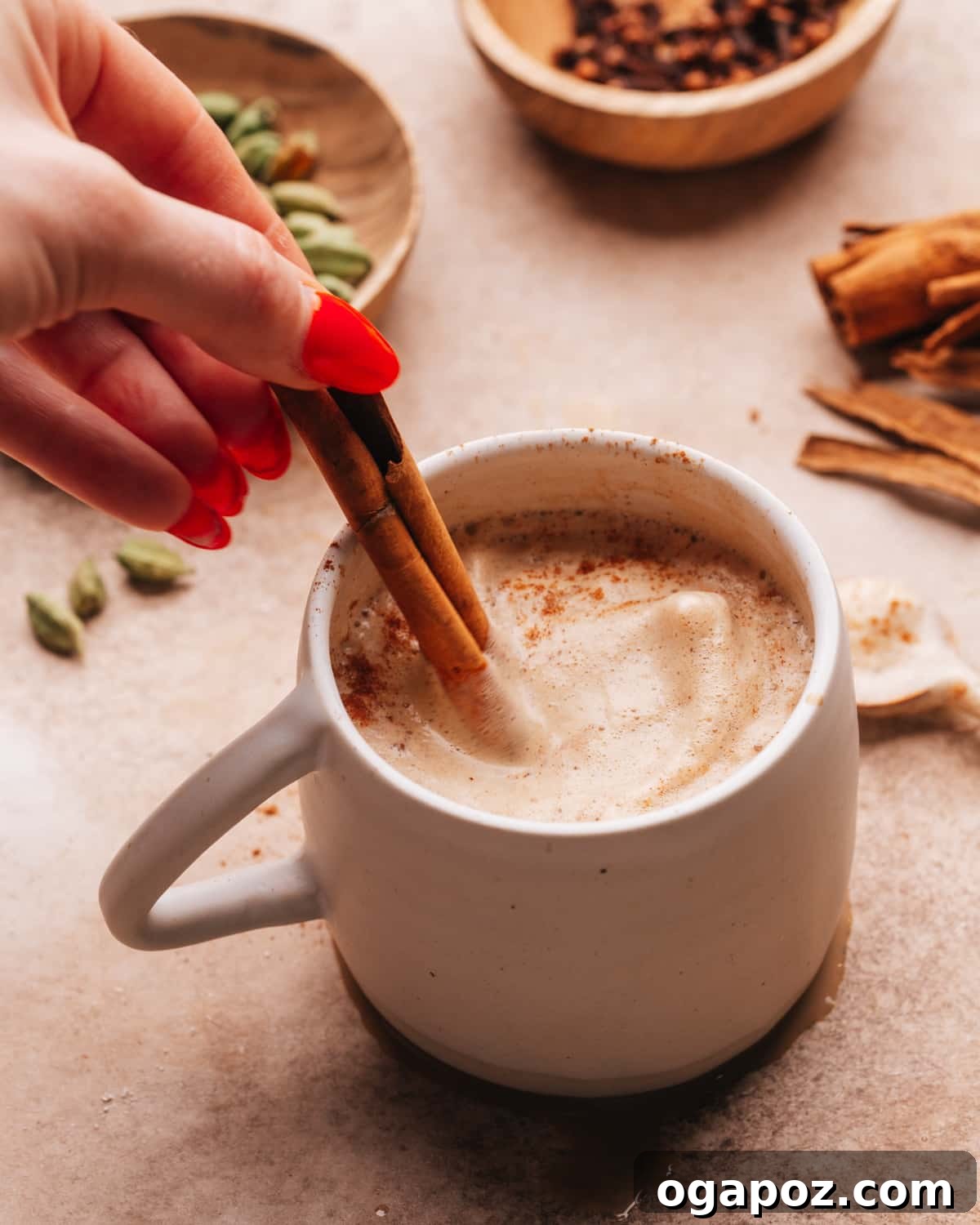 Velvet Froth Chai Coffee Delight 8 Adding a cinnamon stick to a mug of chai coffee as a garnish.