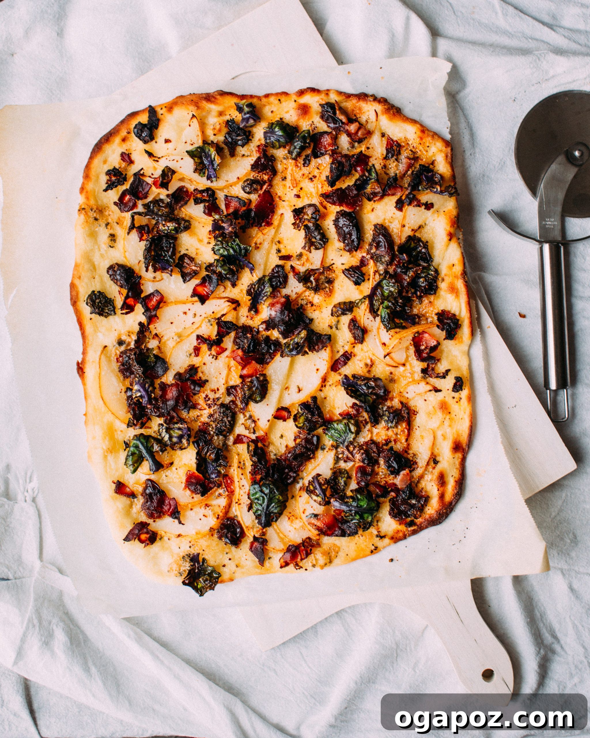 Quick Brussel Sprout Flatbread Bites 2 A delectable Brussels sprout flatbread appetizer, topped with golden-brown ingredients, ready to be served on a rustic wooden board.