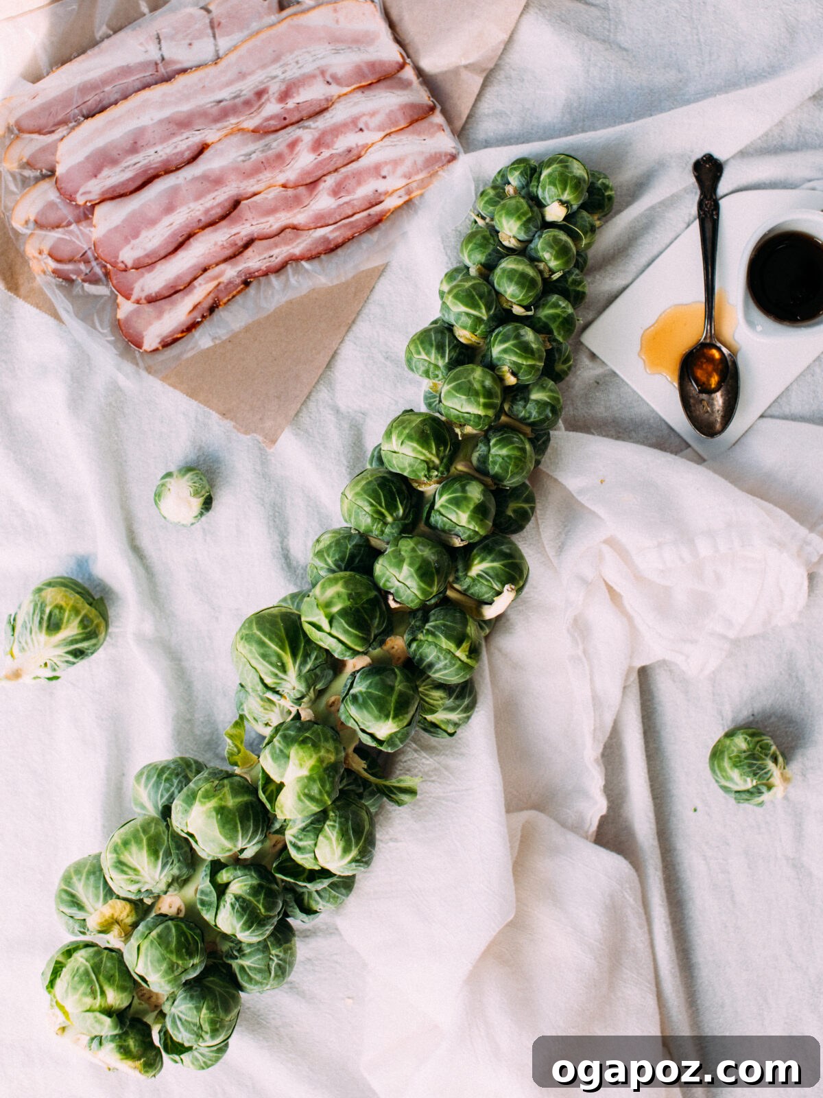 Quick Brussel Sprout Flatbread Bites 3 Crispy Brussels sprouts leaves, golden bacon strips, and a sweet maple syrup drizzle arranged artfully on a white napkin, highlighting the main ingredients of the flatbread.