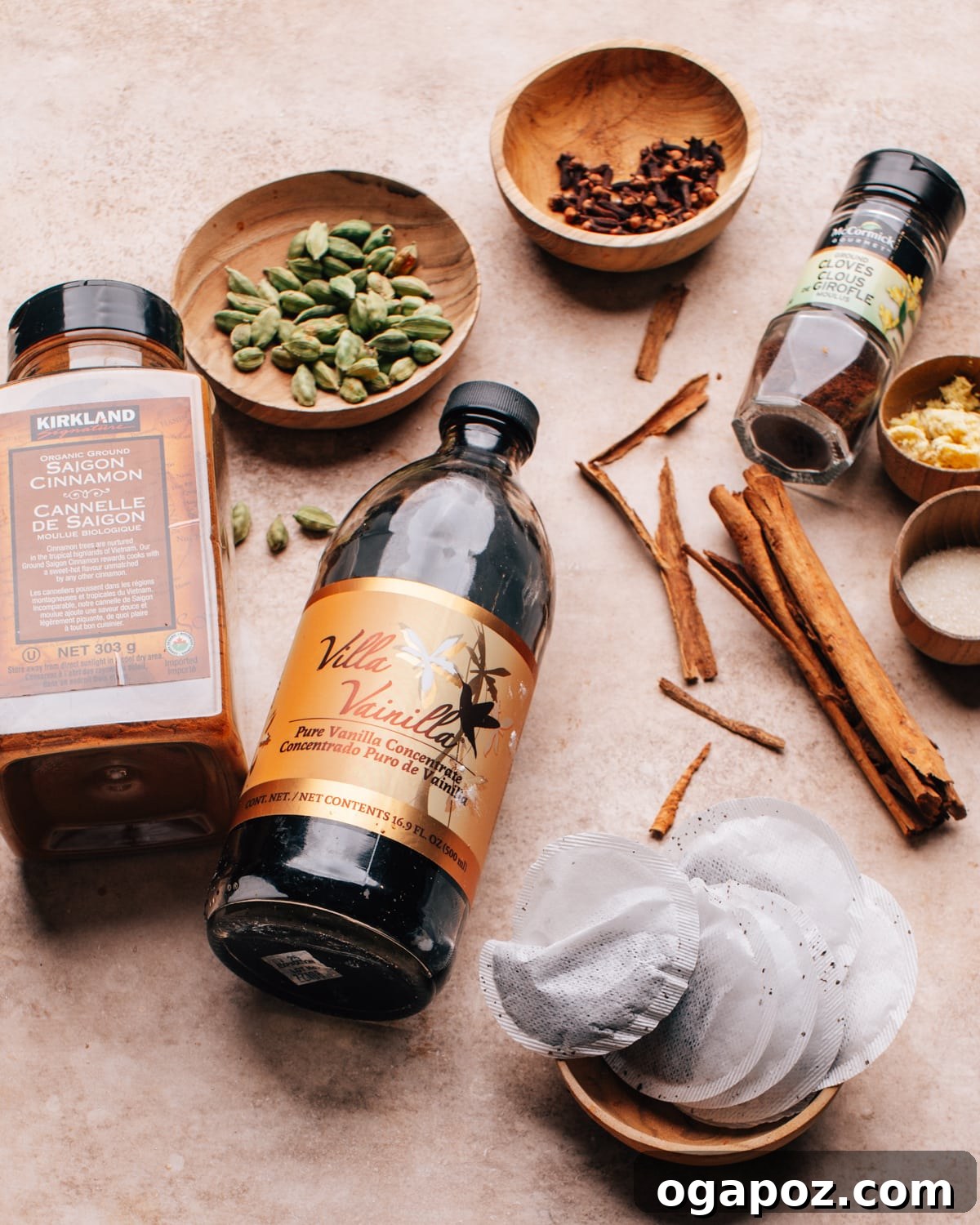 Authentic Chai Concentrate for the Best Homemade Lattes 3 A collection of whole spices and black tea bags, neatly arranged on a rustic surface, representing the fresh ingredients needed for homemade chai concentrate.