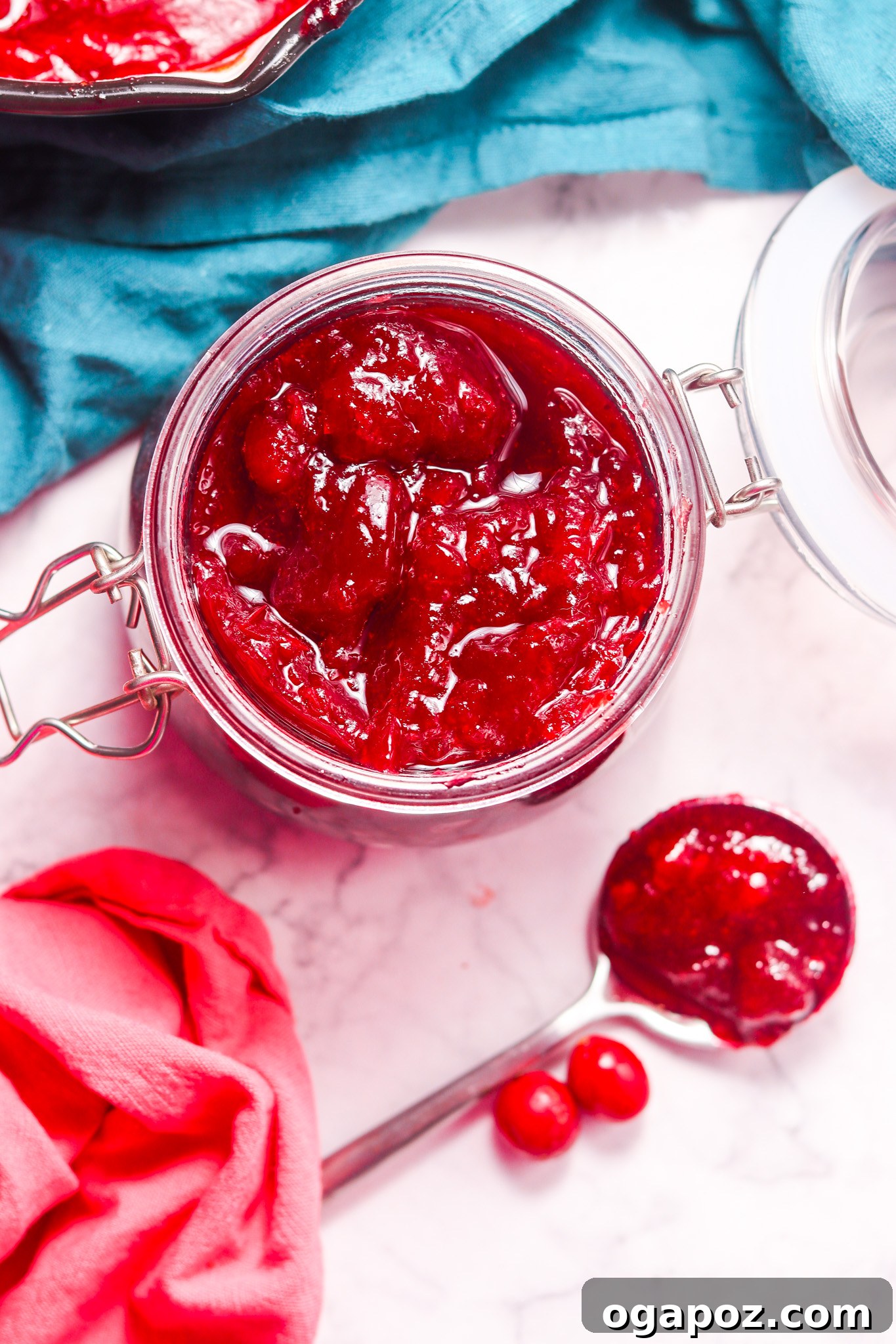 Easy Homemade Cranberry Sauce 6 Homemade Cranberry Sauce Recipe with a spoon resting in a bowl, highlighting its perfect texture and readiness for enjoyment.