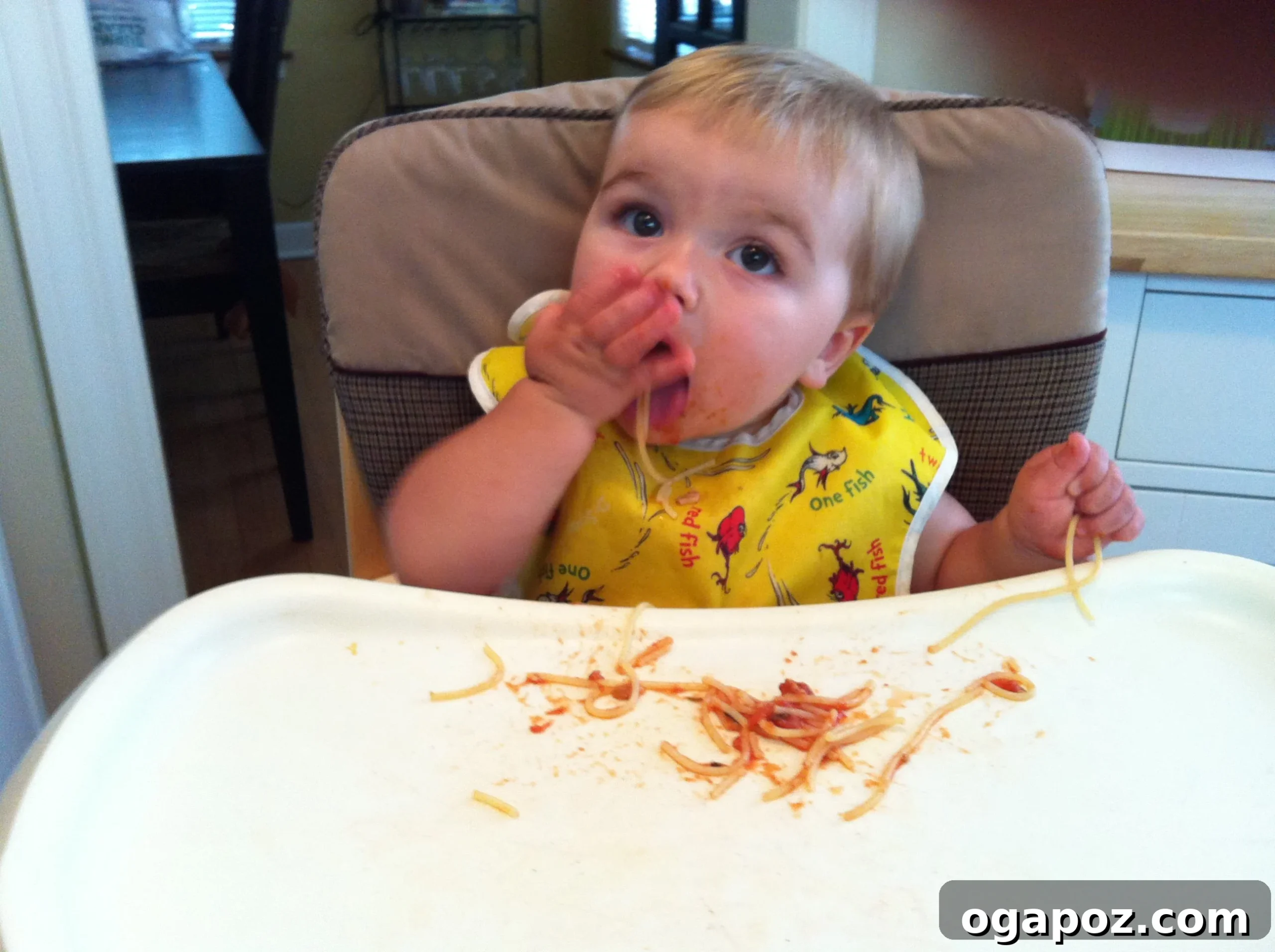 Happy baby eating spaghetti