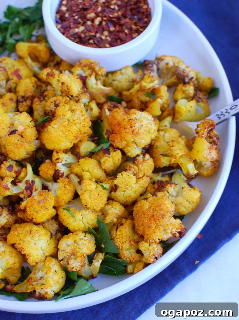 Crispy Air-Fried Cauliflower 2 Crispy Air Fryer Cauliflower on a white plate, garnished with fresh herbs