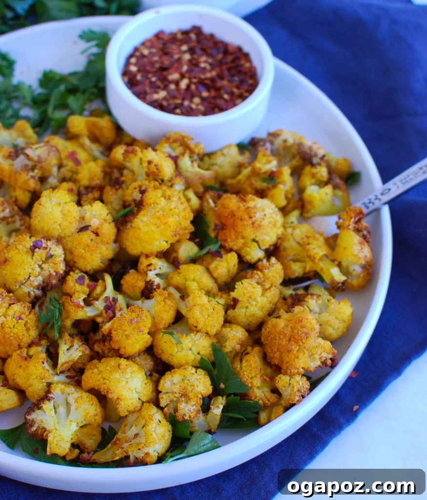Crispy Air-Fried Cauliflower 4 Air Fryer Cauliflower served on a round white plate, garnished with fresh herbs